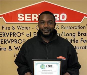 Restoration Technician, male employee holding IICRC certificate
