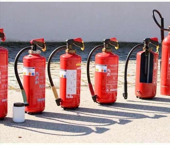 seven red fire extinguishers on the beach