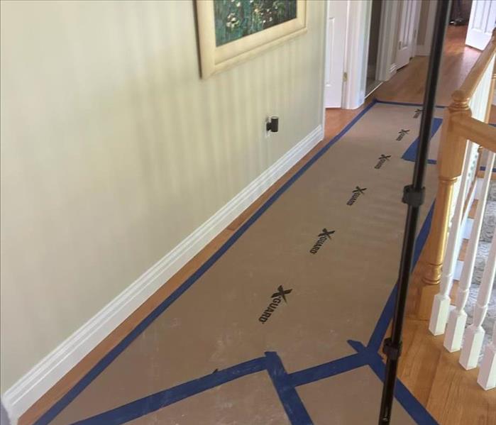 hallway hardwood floor covered with blue tape and plastic